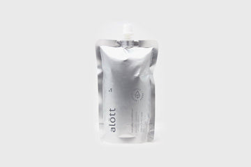 Shiny silver pouch with plastic screw cap and printed branding on grey background  Edit alt text