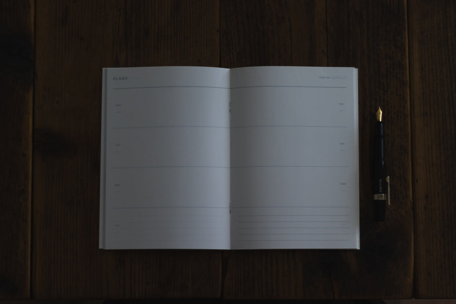 Kartotek Weekly Planner Notebook open on desk flat - BindleStore.