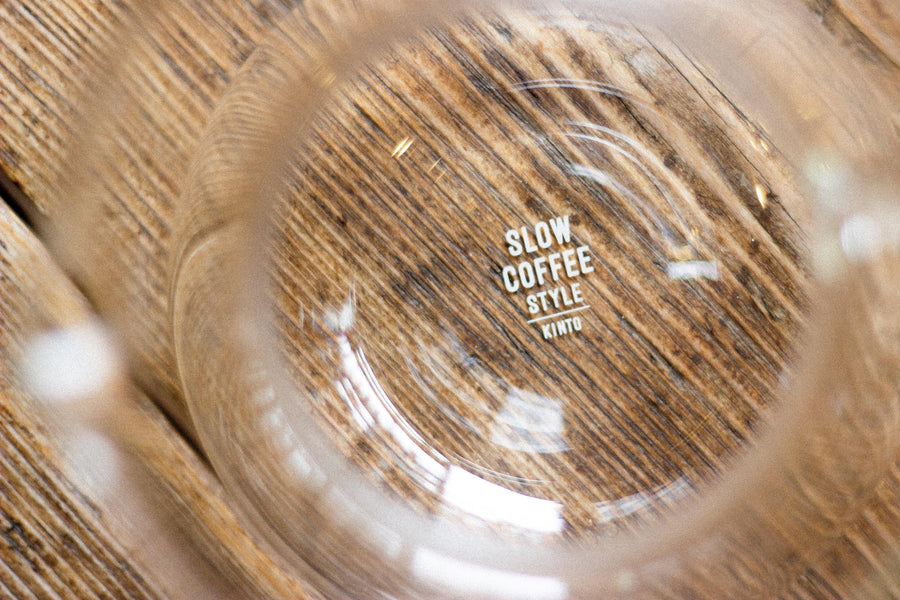 Close up glass carafe with engraved logo on wooden surface