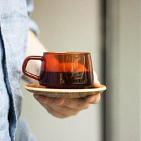 KINTO Sepia cup and saucer held in hand - BindleStore.