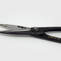 Close up short scissor blades with engraved Japanese characters on grey background