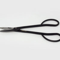 Long handledblack metal  scissors with engraved Japanese characters on grey background 