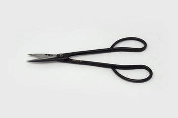 Long handledblack metal  scissors with engraved Japanese characters on grey background 