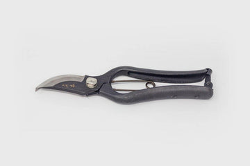 Black metal secateurs with engraved Japanese characters on grey background