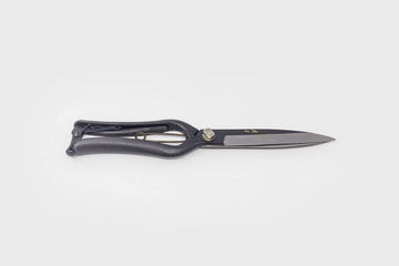 Black metal shears with engraved Japanese characters and long blades on grey background